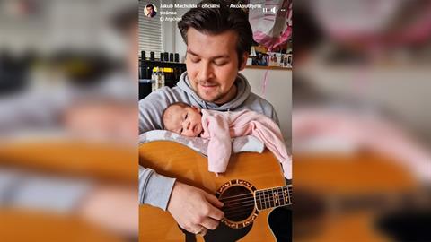 Μπαμπάς κοιμίζει το μωράκι του πάνω στην κιθάρα του ενώ του τραγουδά